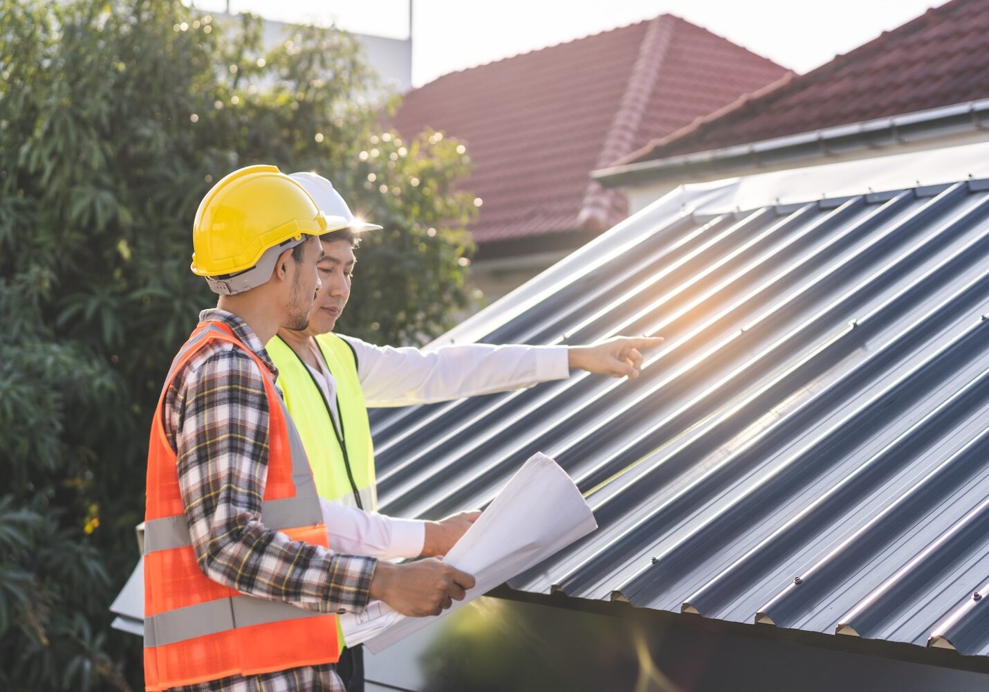 Builder team, foreman house asian young engineer, architect, contractor discussing metal sheet rooftop on blueprint follow project to build industrial plan at outdoor site. Engineering worker people.