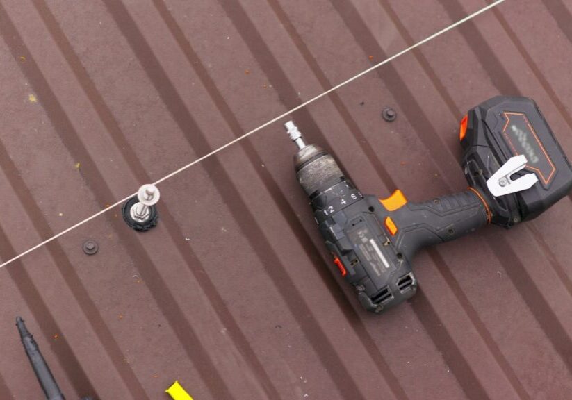 close up tool for roof repair. A screwdriver for tightening bolts and nuts lies on the roof. Installation of mounts for solar panels.