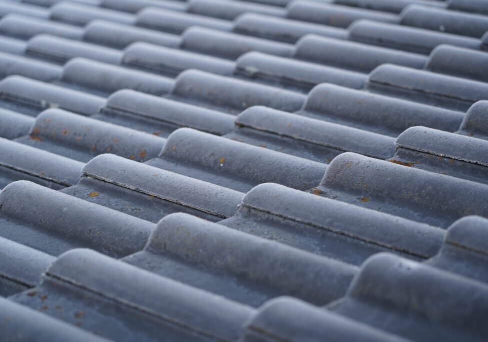 The ribbed roof is covered in frost. Frosty roof in the morning. The tiled roof is covered in frost. Full screen tiled roof.